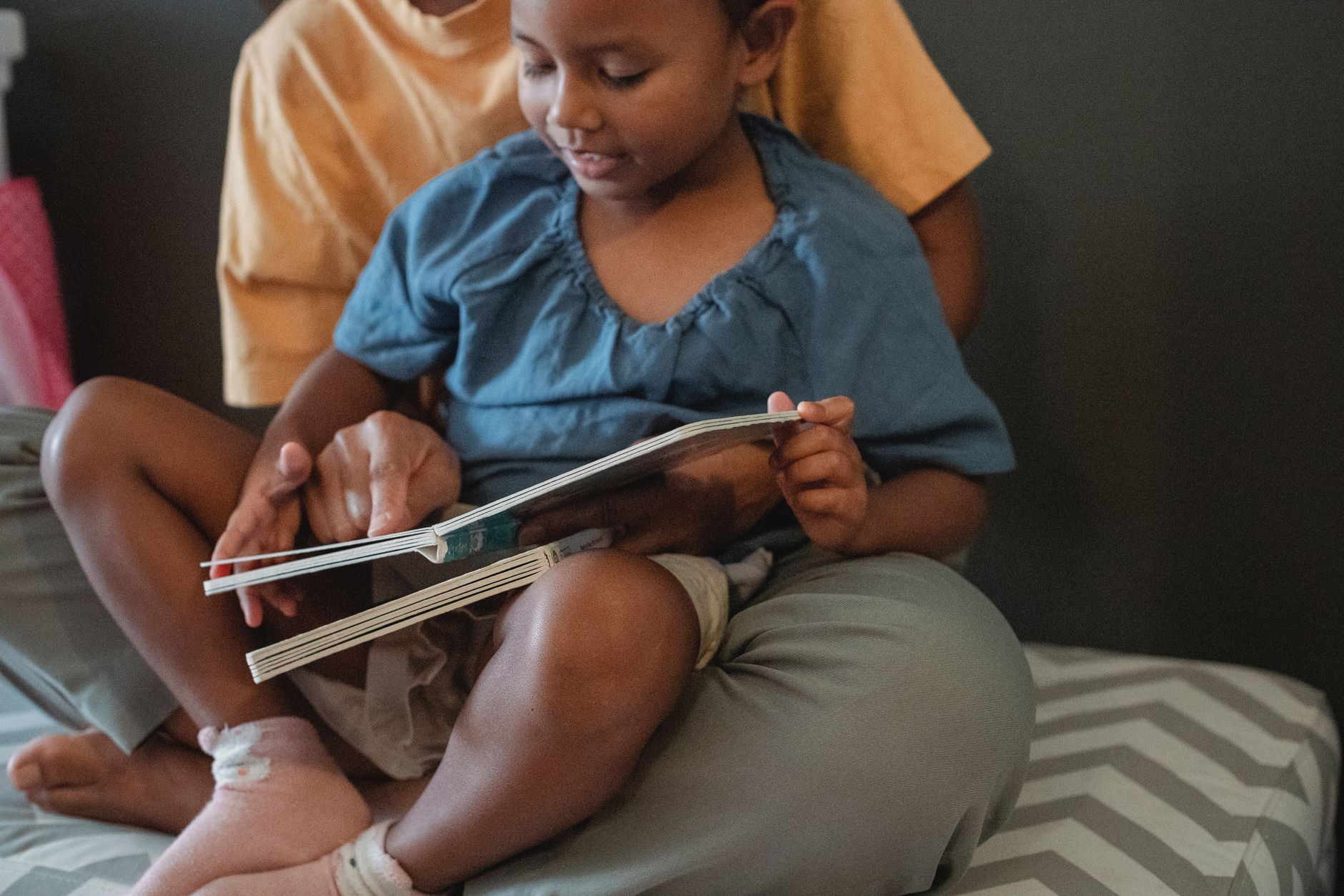 crop asian mother with daughter reading tale